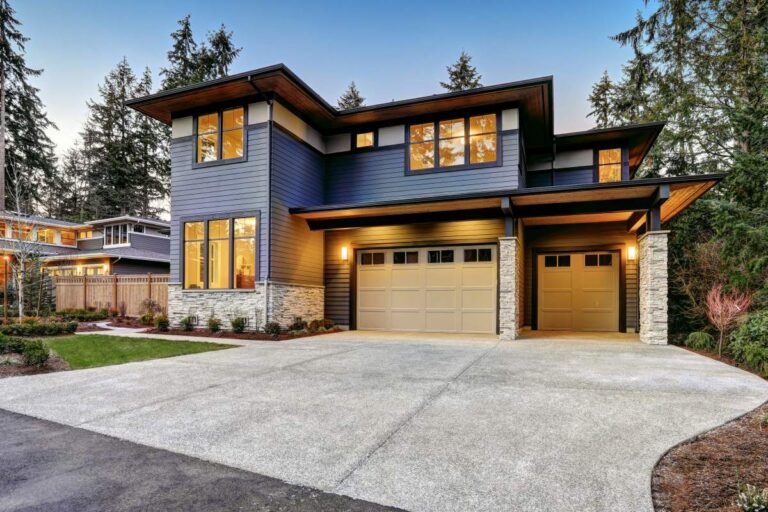 Elevated luxury home overlooking tidal water with a private dock, landscaped yard, and covered outdoor living area.